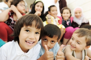 Large group, crowd, lot of happy children of different ages, summer outdoor sitting